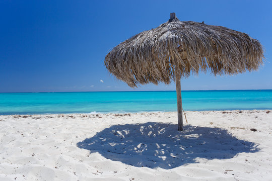 Beach Umbrella made of palm leafs on exotic beach