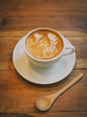 cup of coffee latte art on the wood desk