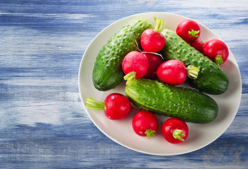 Fresh healthy   radish and cucumbers on  white plate