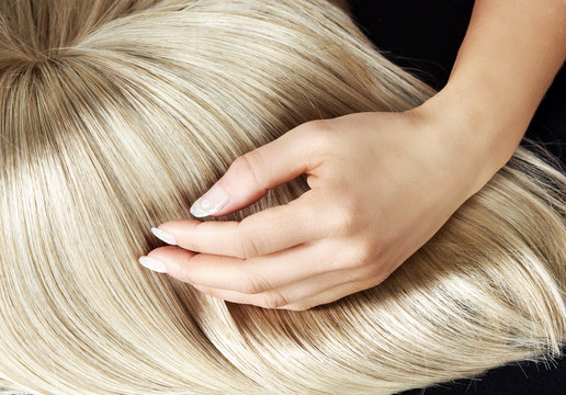 Straight blond wig brushing by a woman