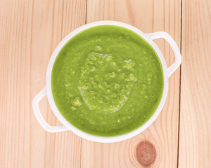 Broccoli cream soup on wood.