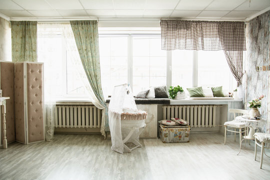 Interior in retro style bright room with a cot and large windows