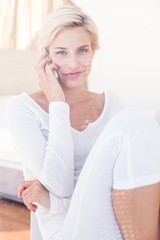 Smiling blonde woman calling on the phone