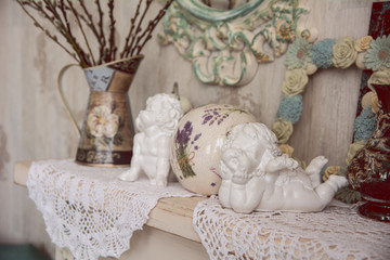 Vintage table with two angels, clocks and knitted cloth