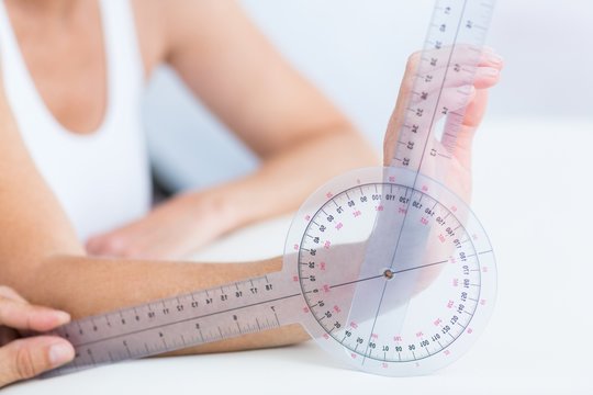 Doctor Measuring Wrist With Goniometer