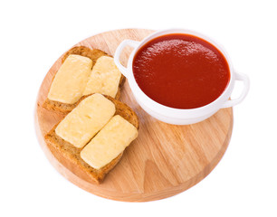 Bowl of tomato soup on board.