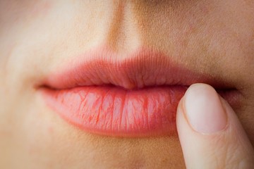 Fototapeta premium Woman pointing to her lips