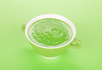 Bowl of tomato soup on a green.