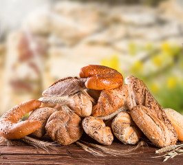 Variety of bread on wooden table with nature background