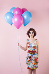 Woman with curly hair holding balloons