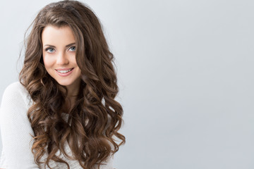 Portrait of a beautiful young woman with wavy hair.