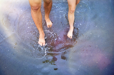 Unrecognizable woman and man in barefoot in a puddle