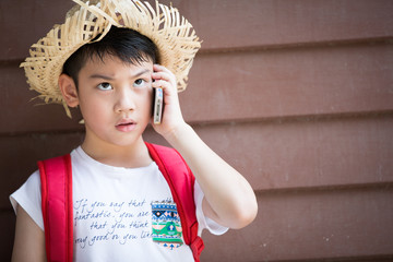 Asian boy speaks by phone