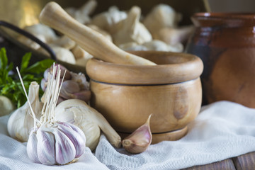 Bodegón de mortero con ajos y perejil en la mesa de la cocina