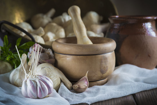 Bodeg&oacute;n de mortero con ajos y perejil en la mesa de la cocina