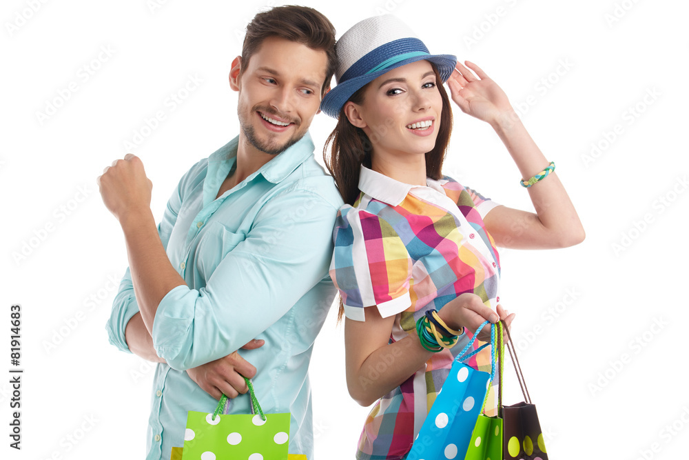 Sticker Attractive young couple with shopping bags on white background