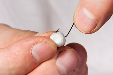 foam ball on the hook in hands of fishermen