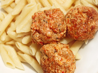Three meatballs with sauce over pasta