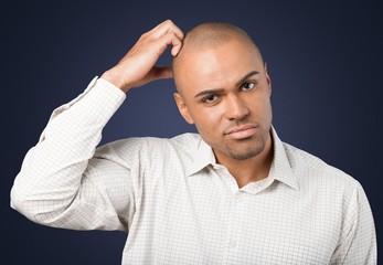 Confusion. Confusion - Young man scratching his head on white