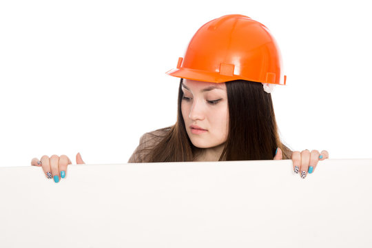Girl builder in helmet looking at a blank banner.