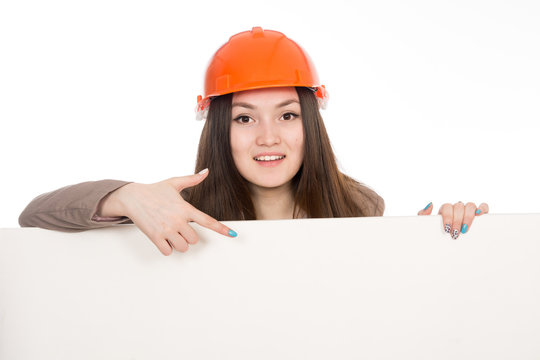 Girl builder in helmet showing a finger on a blank banner