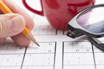 Sudoku puzzle, pen and glasses