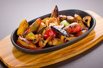 Warm thai salad in a black plate over wooden background