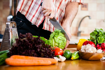 Man cuts fresh spring vegetables