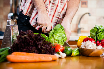 Man cuts fresh spring vegetables