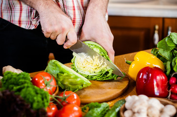 Man cuts fresh spring vegetables