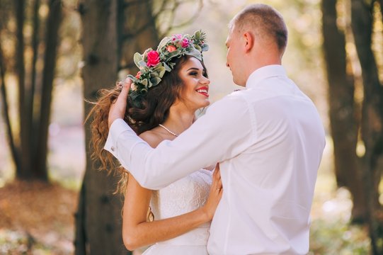 happy bride and groom walking in the autumn forest