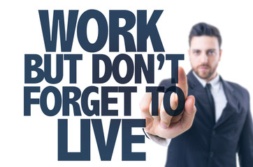 Business man pointing the text: Work But Don't Forget to Live