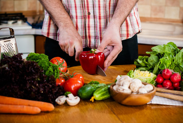 Man cuts fresh spring vegetables