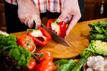 Man cuts fresh spring vegetables