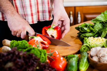 Man cuts fresh spring vegetables