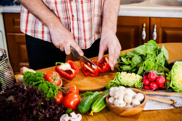 Man cuts fresh spring vegetables