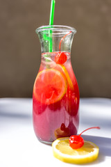 Lemonade in the jug with straws and lemons