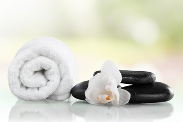 Fototapeta na wymiar Spa Treatment. Towel, gladiola and pebbles for massage