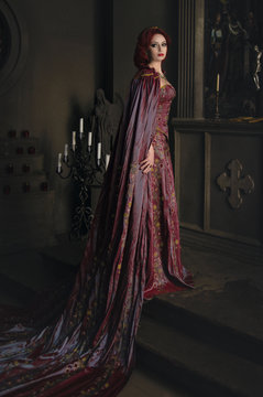 Woman with red hair wearing elegant royal garb 