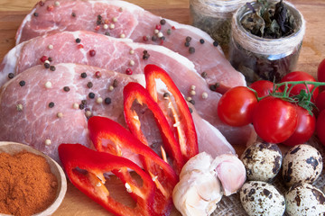 Raw meat cut into steaks or cubes on board with vegetables