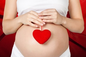 Love. Pregnant mother showing her belly and holding a gift