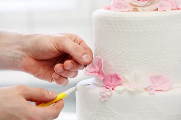 Confectioner decorates wedding cake