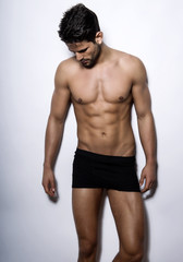 handsome young bodybuilder showing of his fit body and muscles