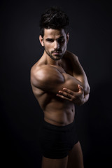 handsome young bodybuilder showing of his fit body and muscles