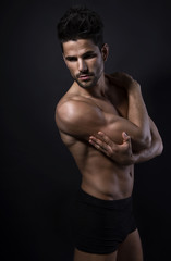 handsome young bodybuilder showing of his fit body and muscles