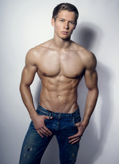 handsome young bodybuilder showing of his fit body and muscles
