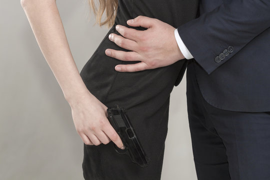 Caucasian Unrecognizable Man And Woman In Black With A Gun