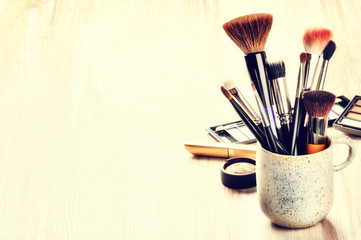 Various makeup brushes on light background - 81936476