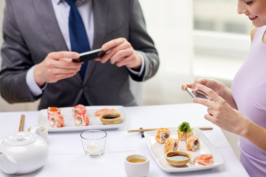 close up of couple with smartphones at restaurant