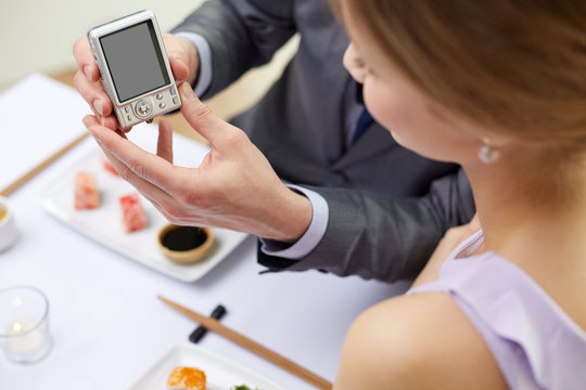 close up of couple with camera at restaurant